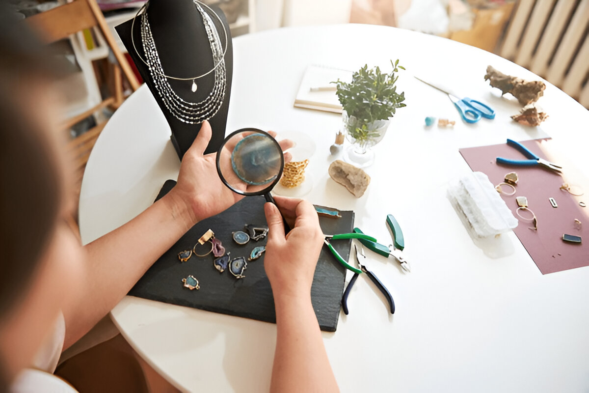 Craftswoman inspecting a gemstone through a magnifying glass