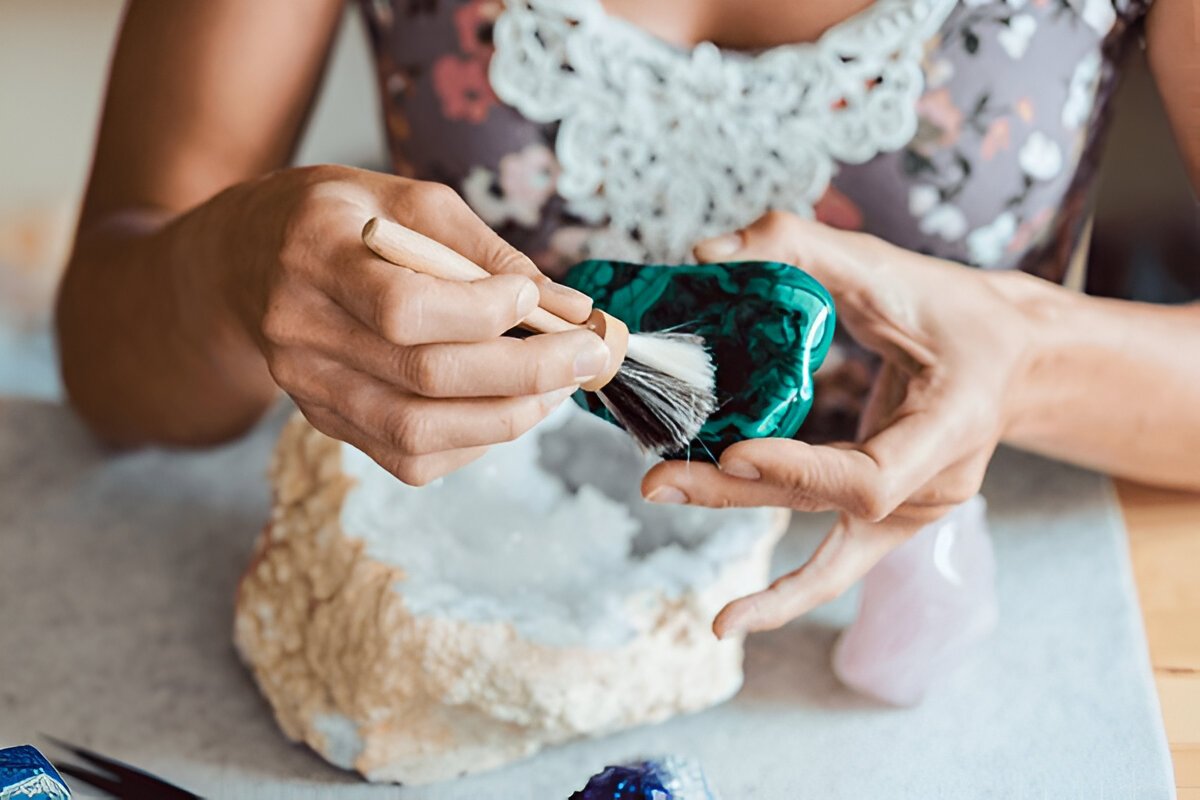Young woman dusting a malachite with a brush