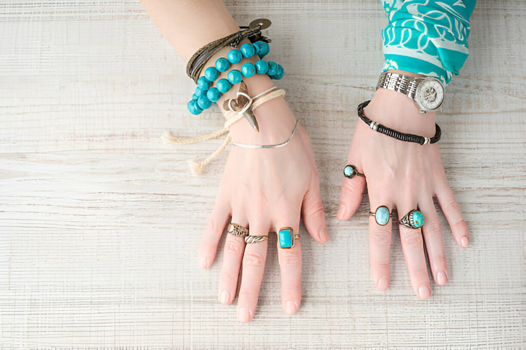 Hands of women in the jewelry of turquoise