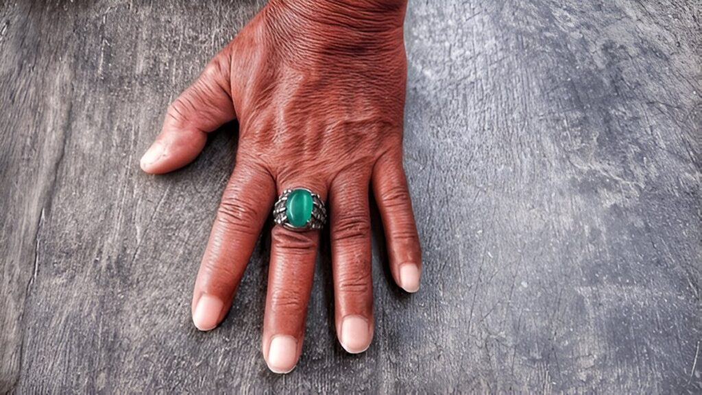 naturally textured skin wearing a ring with an emerald ring